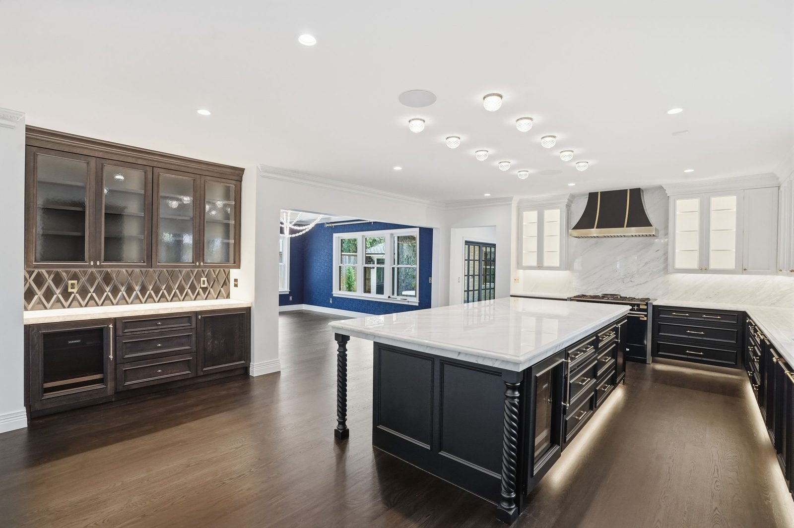 Remodeled kitchen with marble island and custom range hood built by Turner2 Renovations